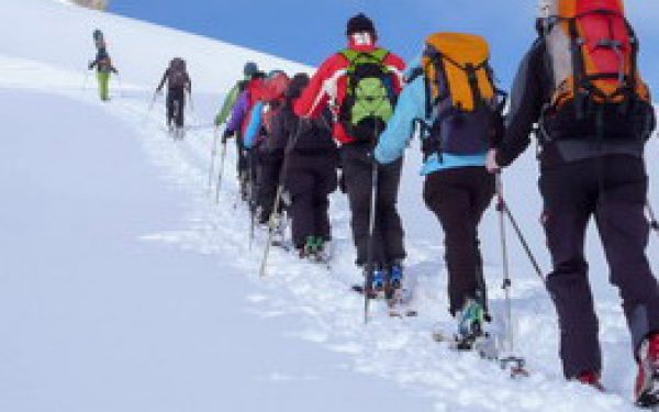 a mountain guide and his clients on a backcountry ski tour in th